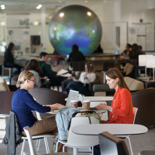 Two students working together at desk.