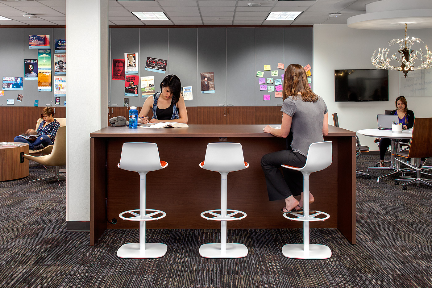 Students working at raised desk of a room.