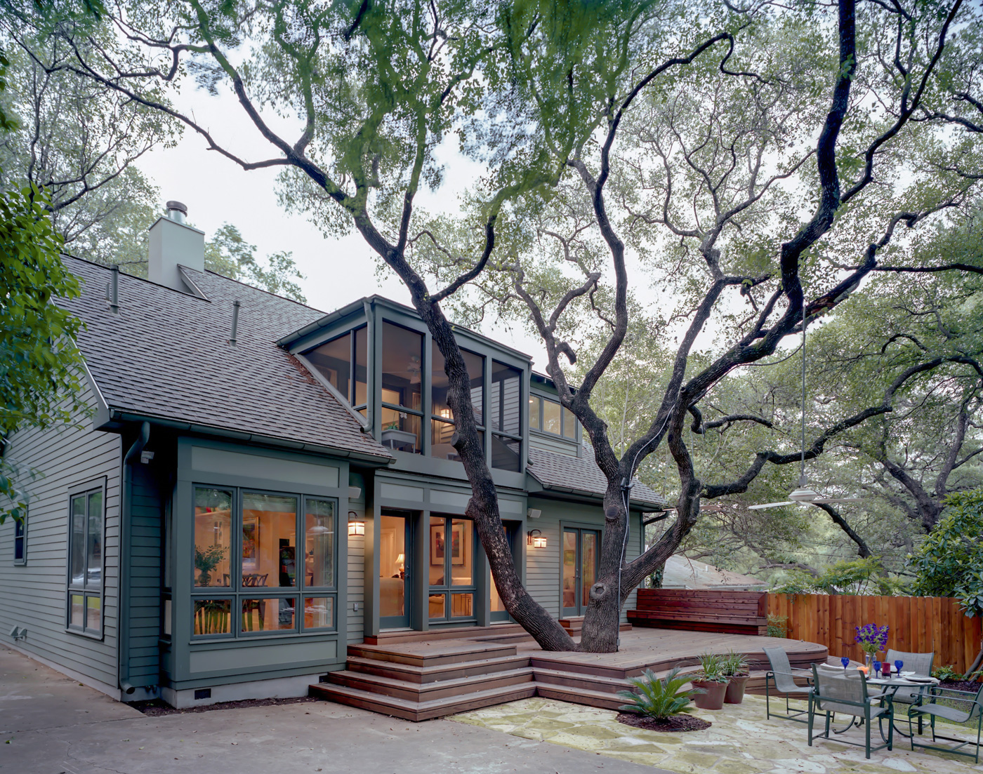 A large tree in center of backyard deck.