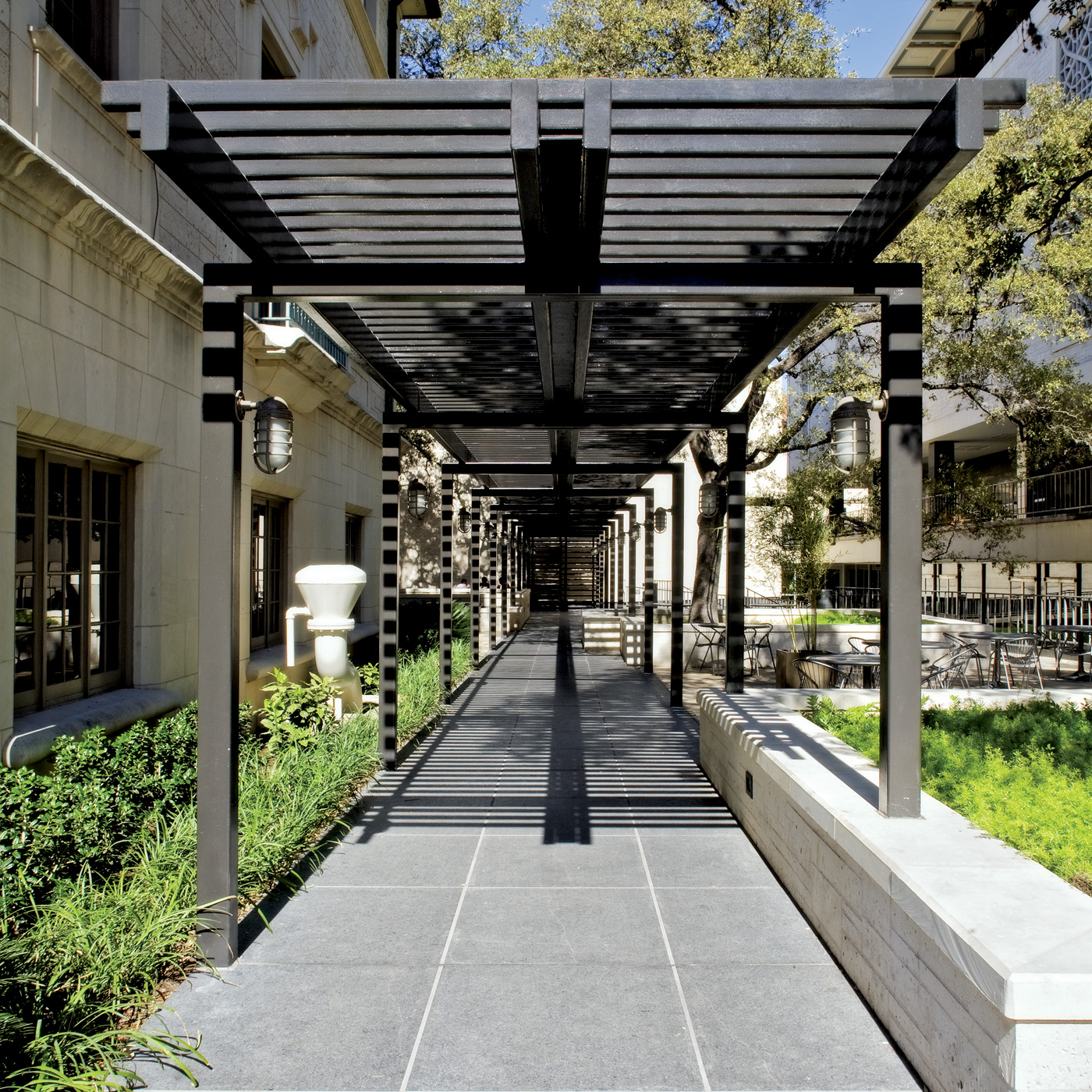 An awning spanning above a walkway that boarders university buildings.