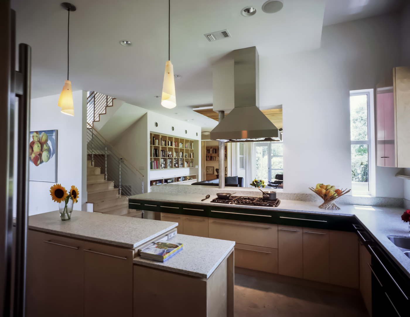 A kitchen with open view to stairs and living room.