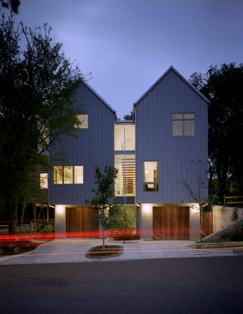 Symmetrical tall house seen from its street.