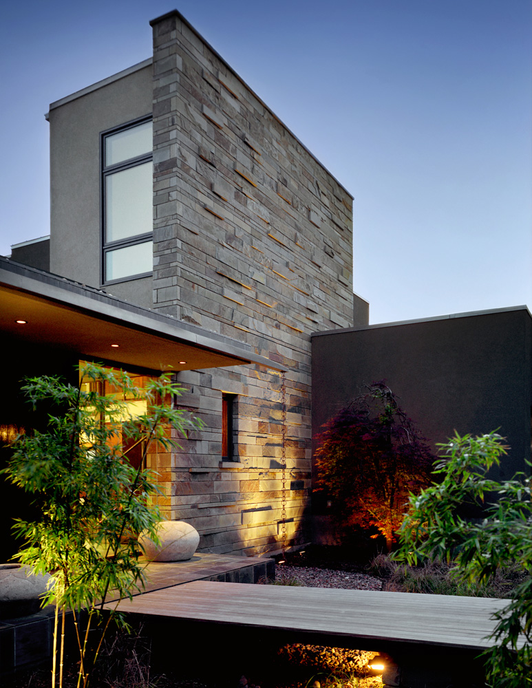 Floating wood path to front entrance of modern home.