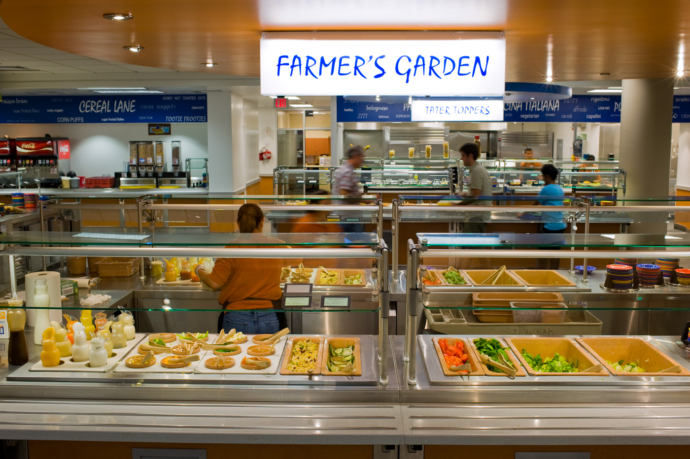 People serving themselves in a dormitory dining hall.