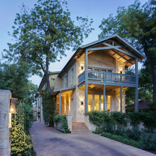 A house and its brick driveway leading to a street.