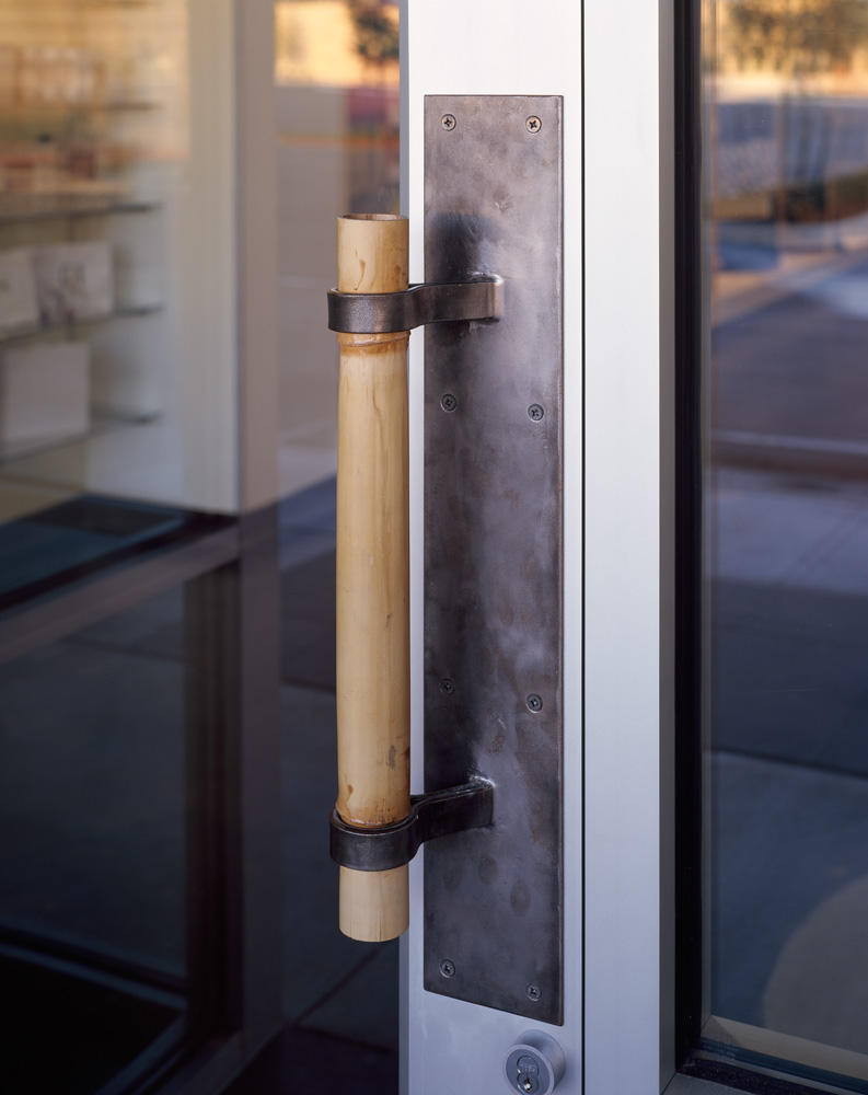A bamboo door handle to a stores front door.