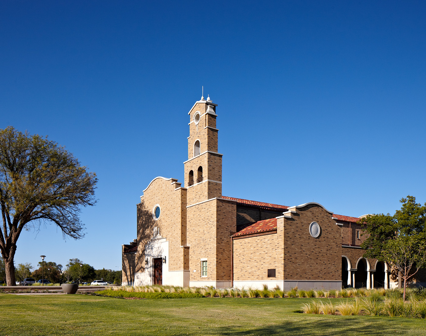 A brick chapel and its neighboring lawn.