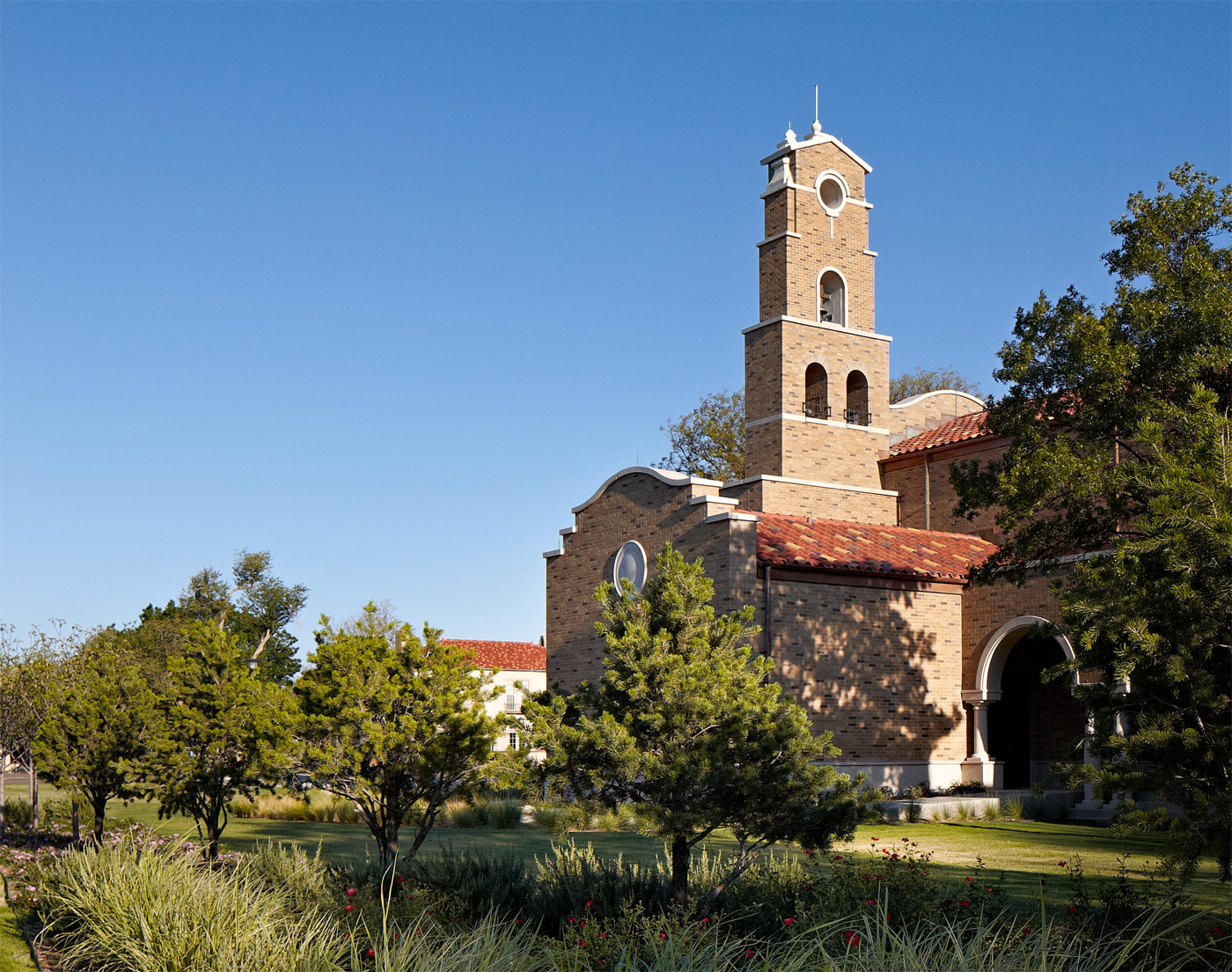 A brick chapel and its surrounding trees.