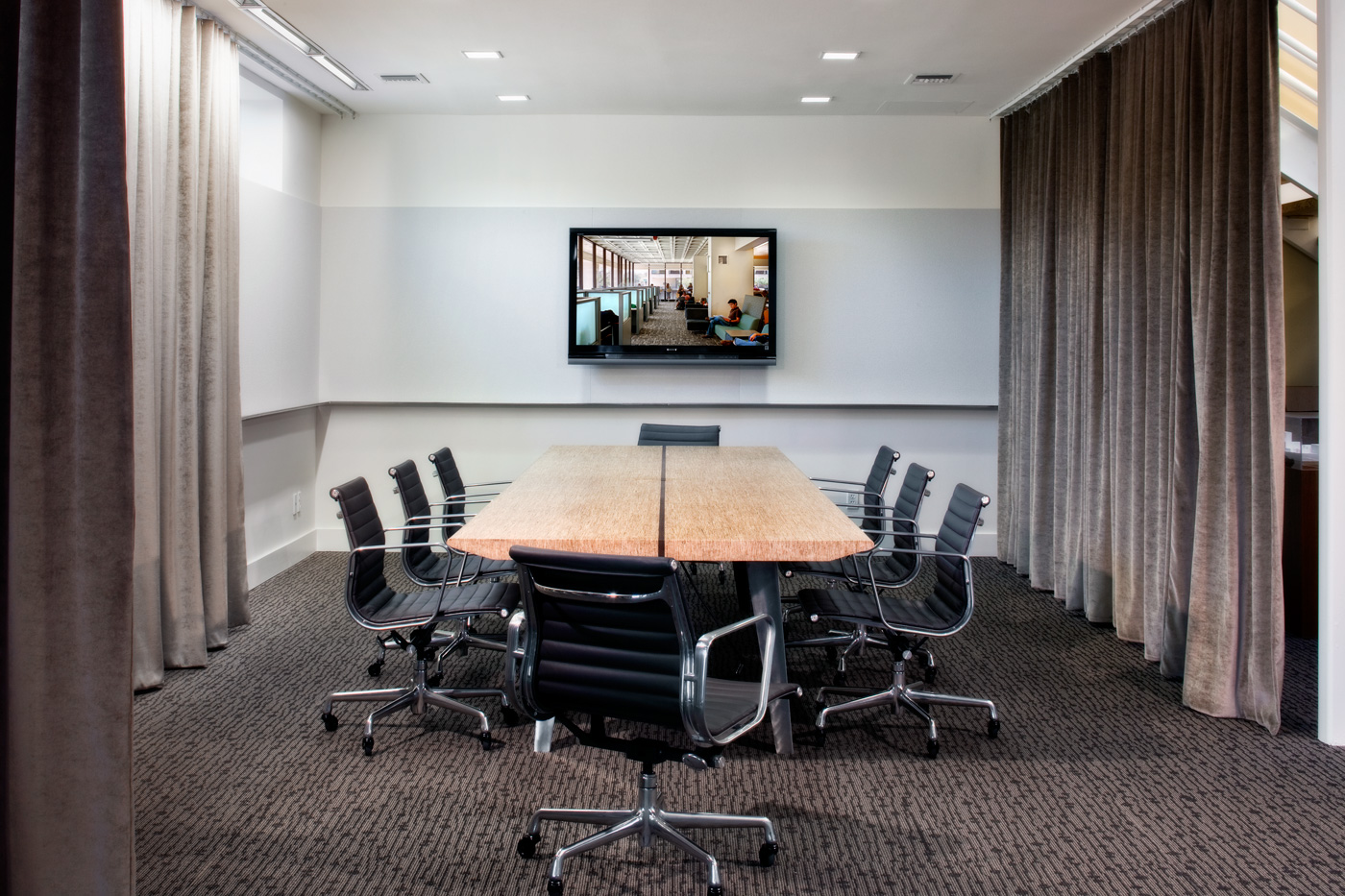 An offices large conference room with wrap around curtains.