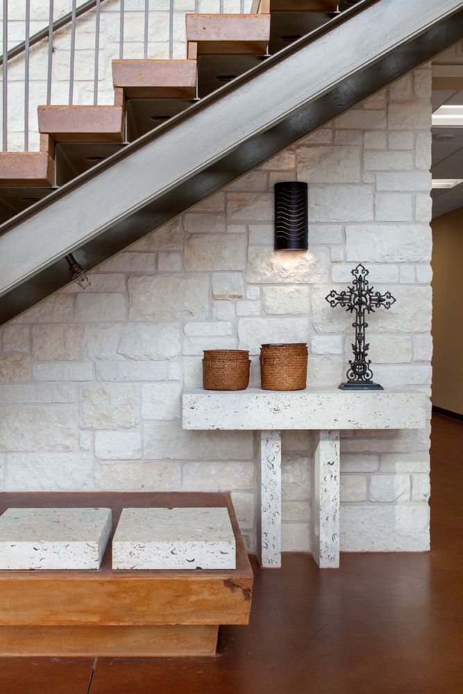 stone stand holding up a cross beneath a set of stairs.