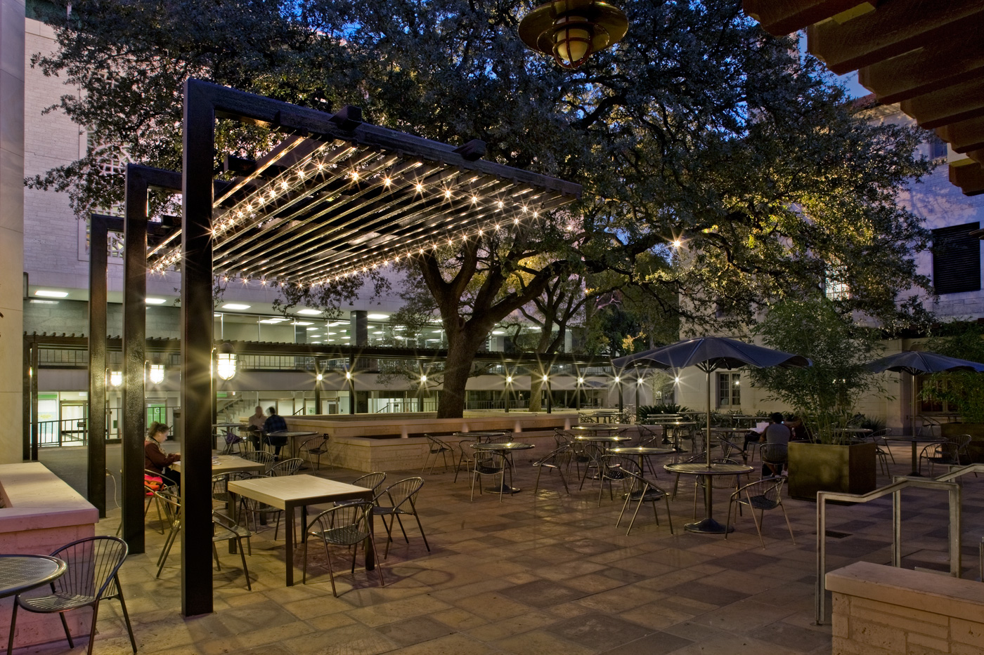 A large seating patio of University of Texas at night.