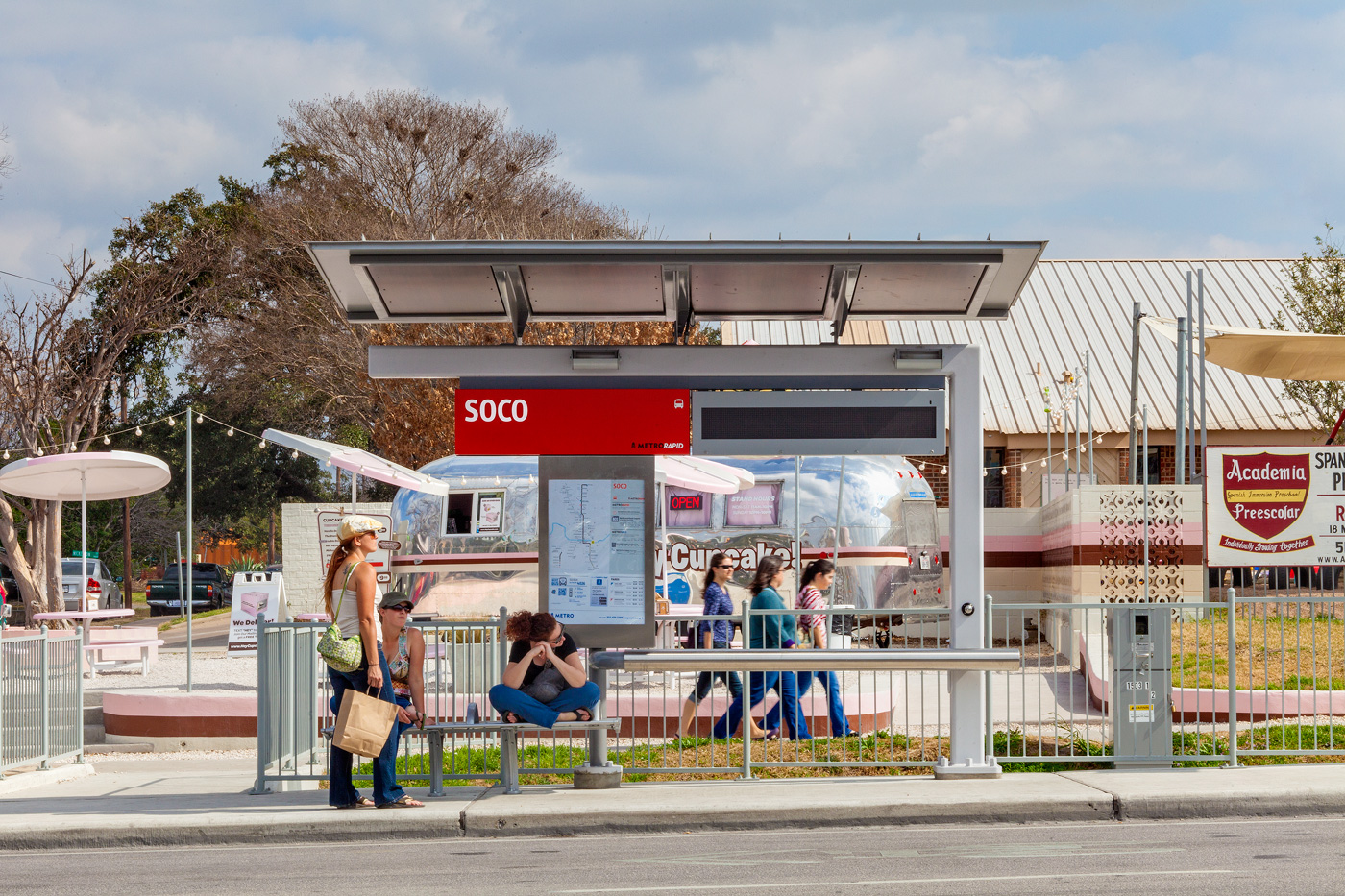 People waiting for bus at a modern bus stop on South Congress.