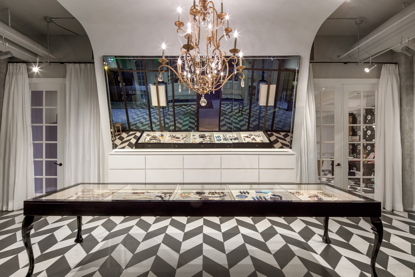 A large chandelier over a confections display case.