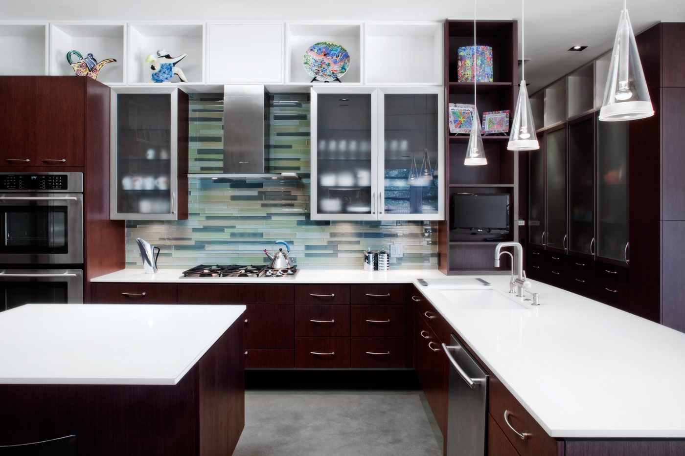 Modern kitchen with dark wood cabinetry and metal appliances.