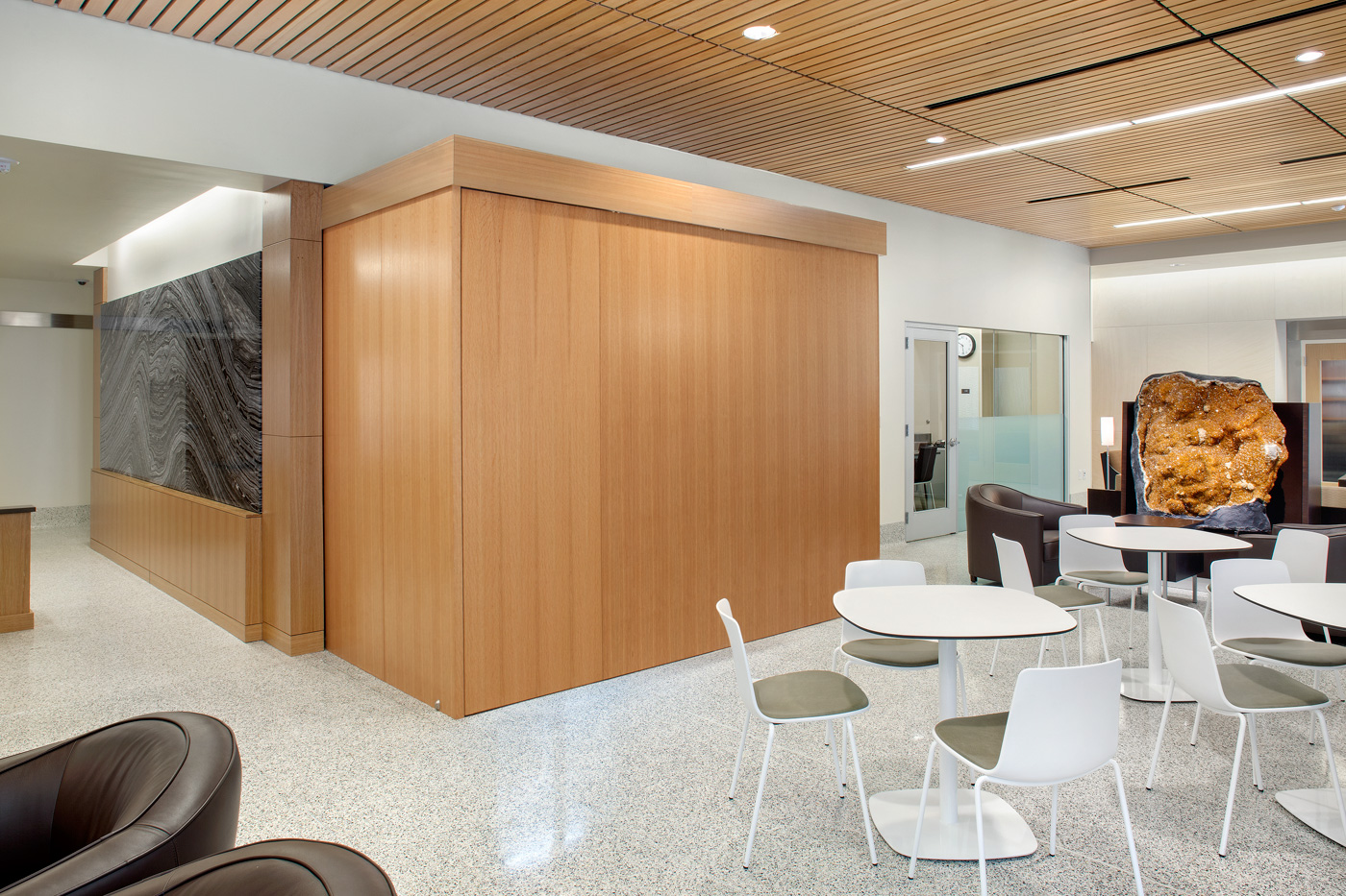 Lounge chairs and table arrangements in open lobby seating area.