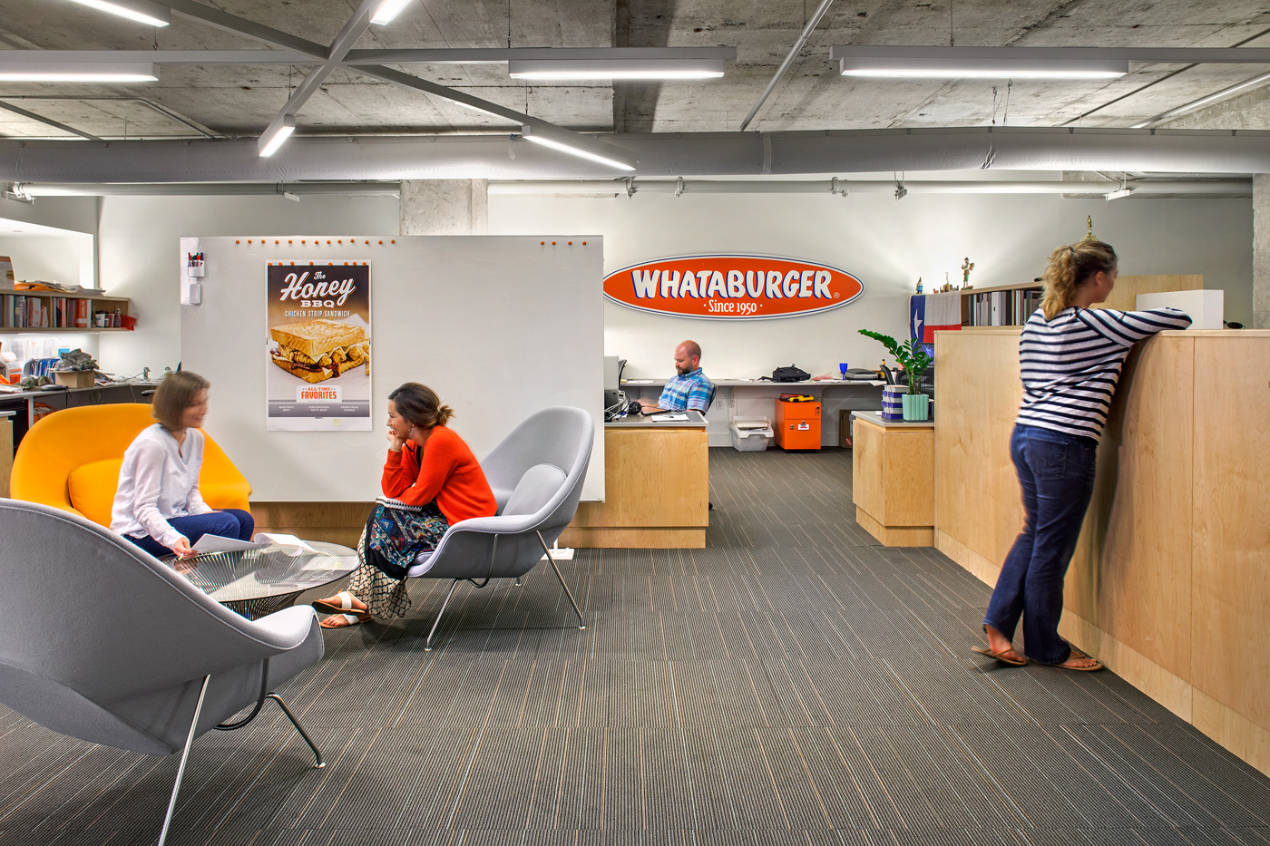 People working in an office with diverse seating opportunities.