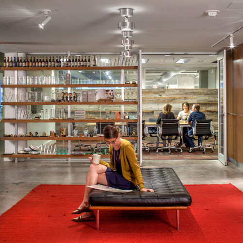 Women reading at a bench in an office.