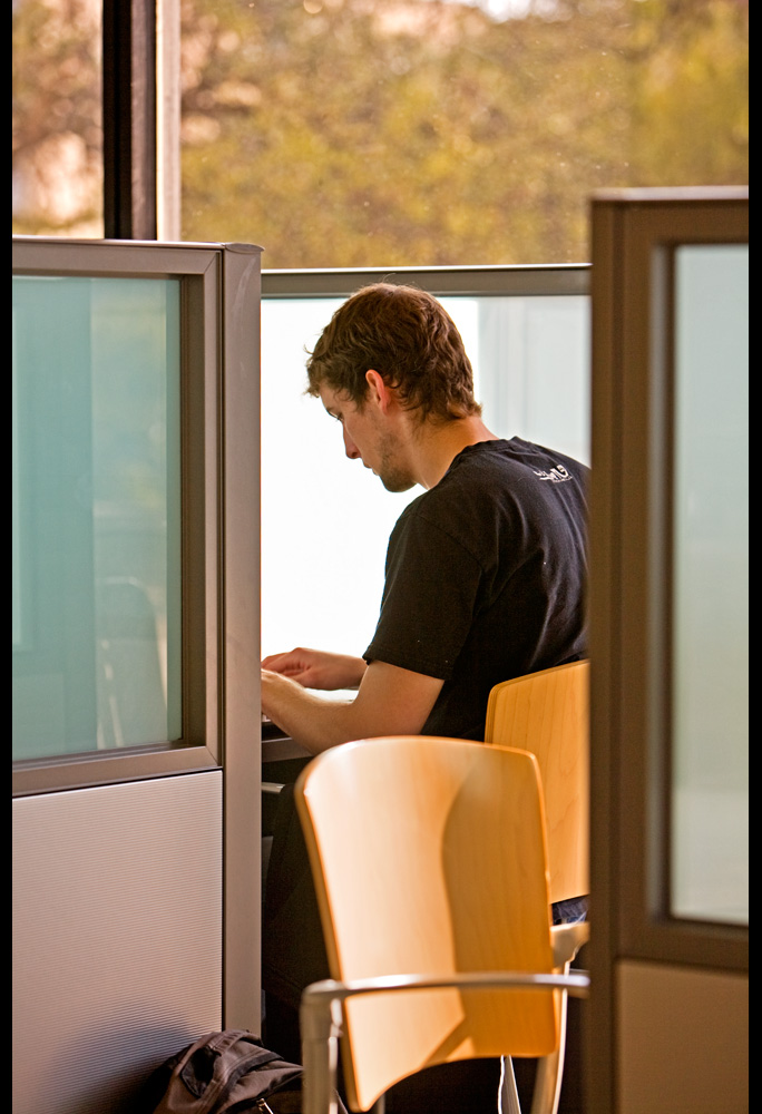 Student working diligently in a study cubical.