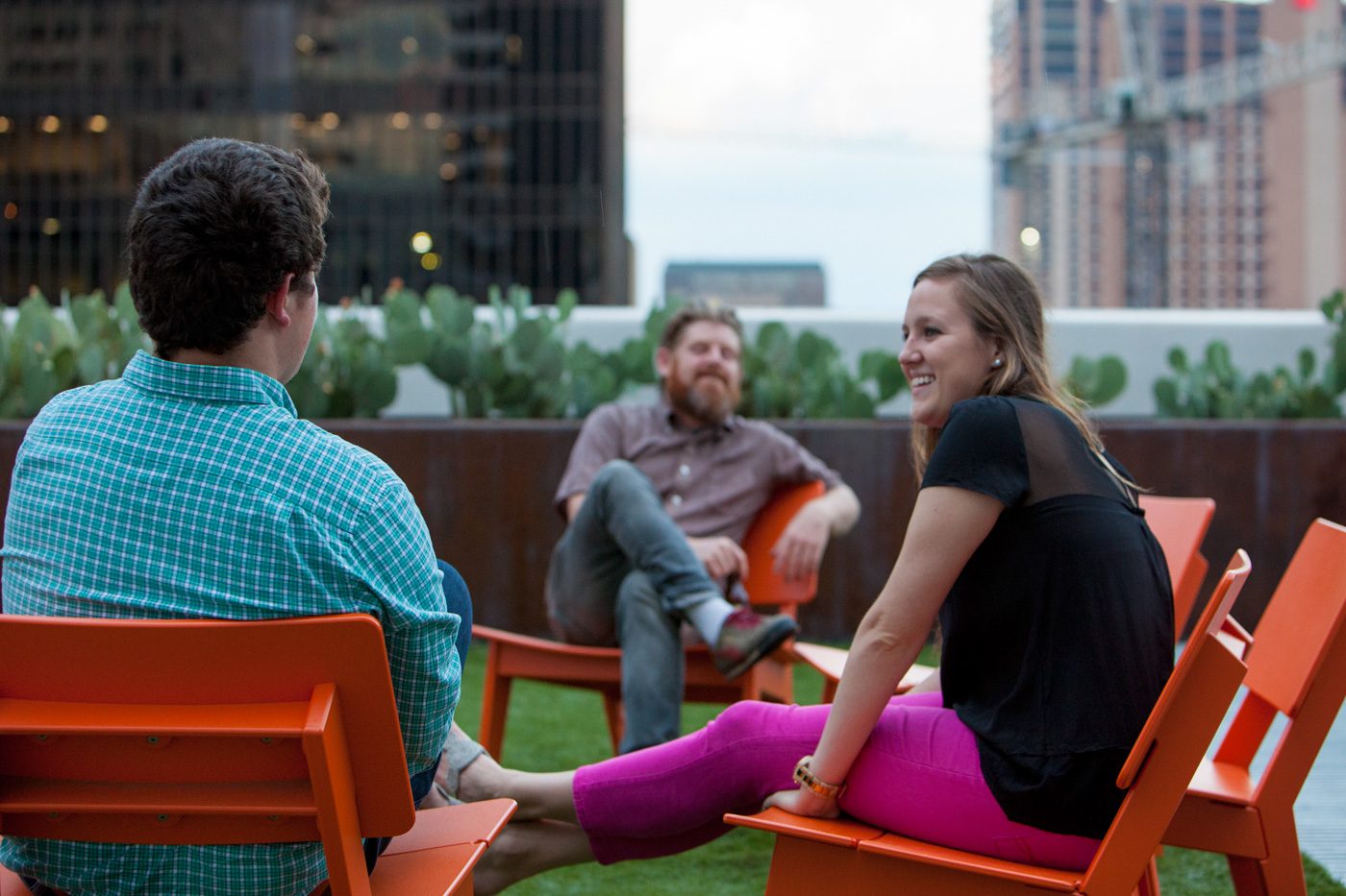 People socializing on a downtown rooftop deck.