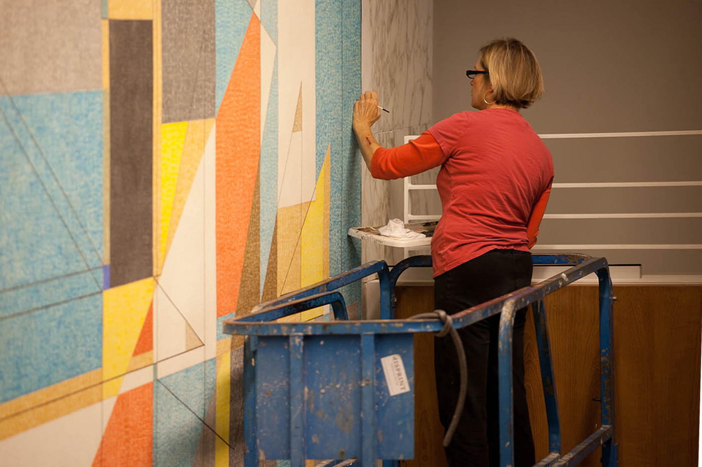 A woman restoring a historic mural.