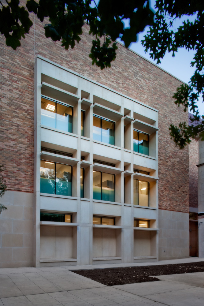 A light shadowing structure build into wall of a large brick college building.