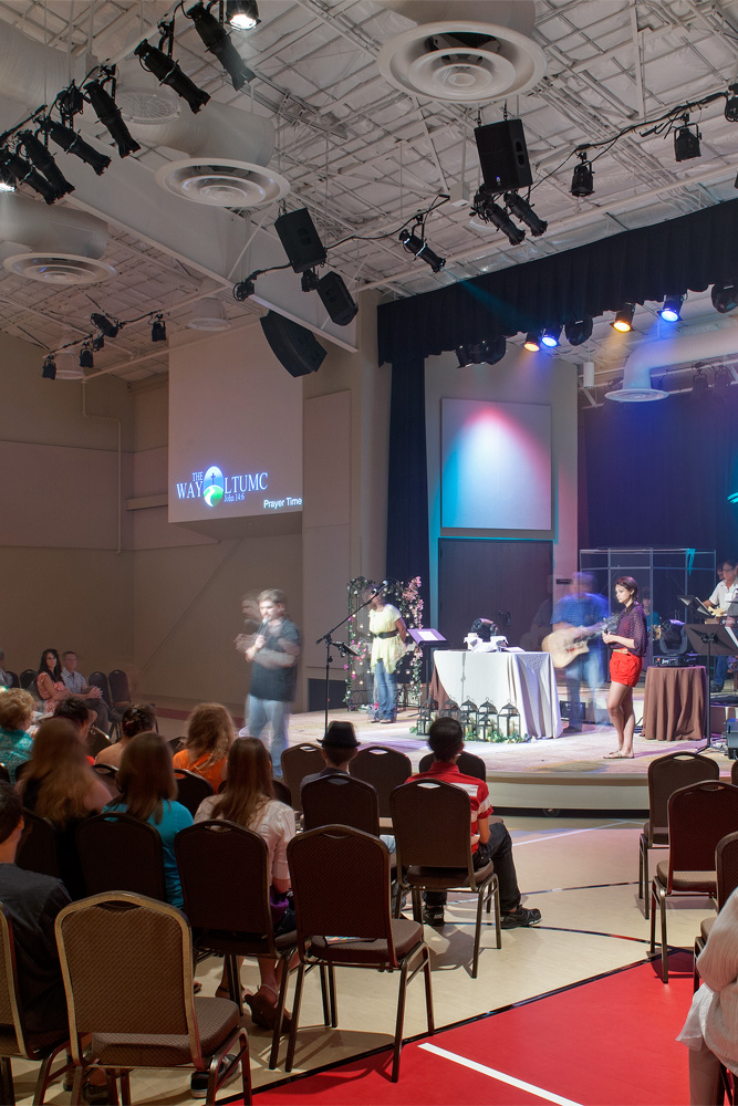 People preforming to audience inside a church's auditorium.