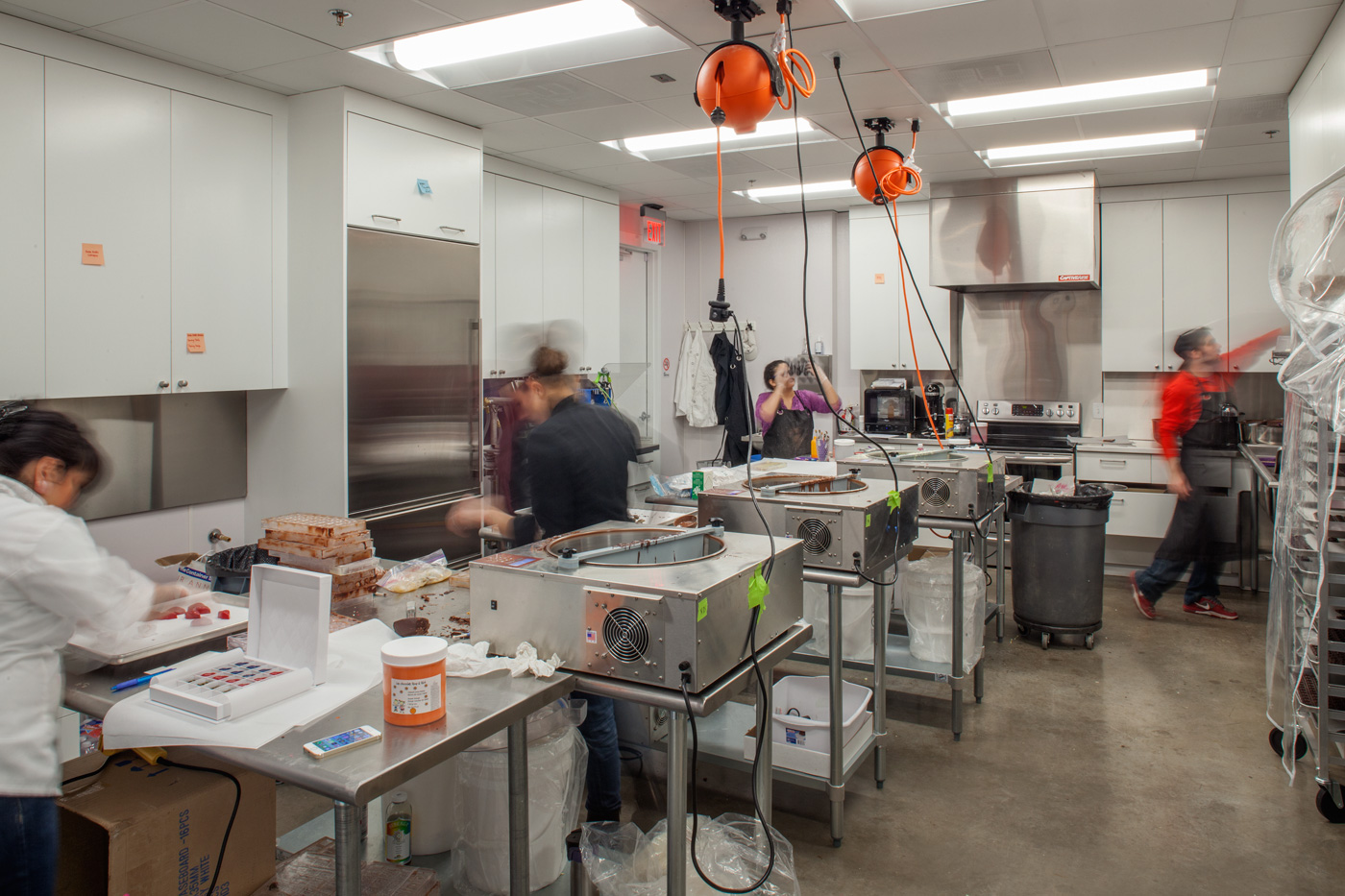 Workers in the back kitchen of a confections store.