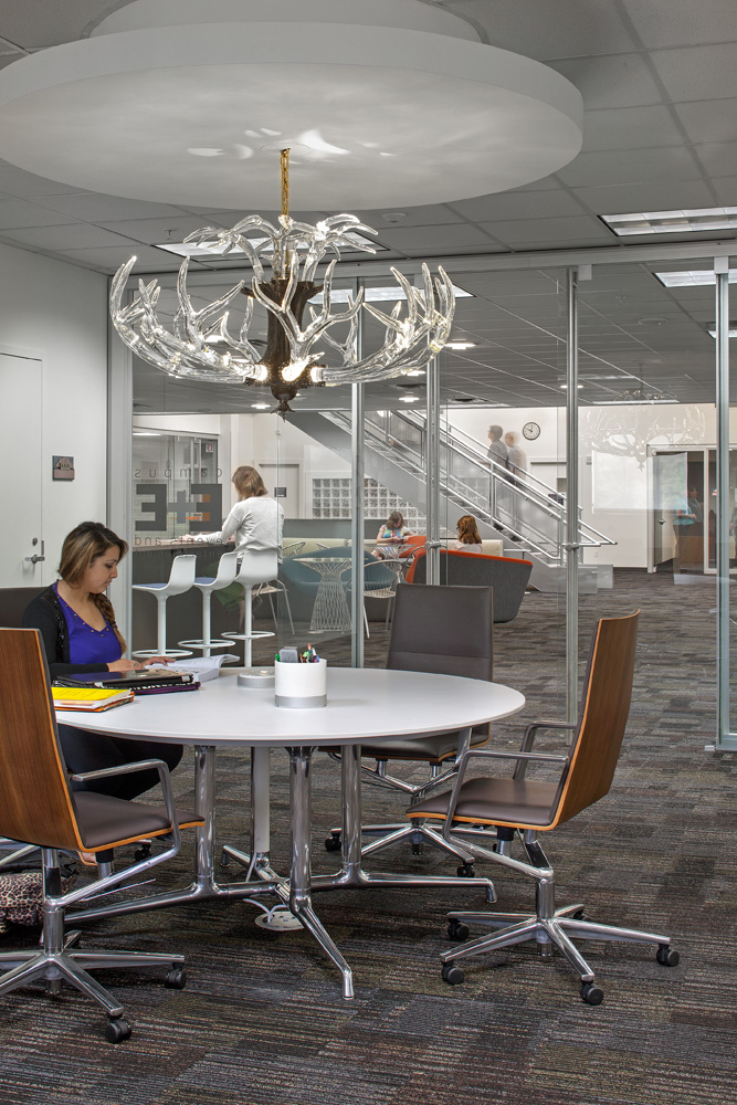 A conference room with a decorative hanging lighting ficture.