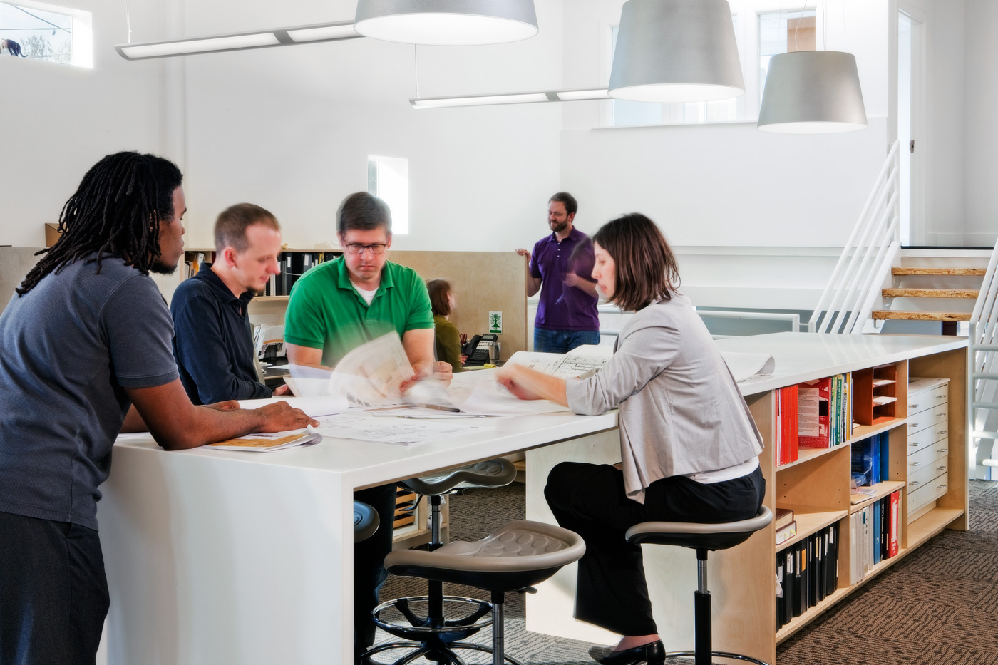 Architects working around large standing table.