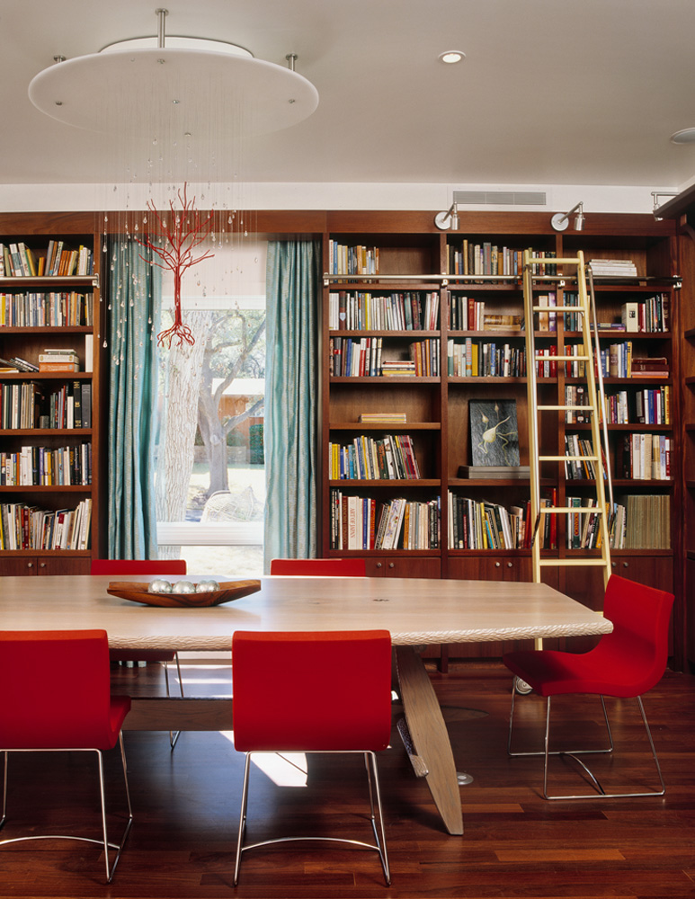 A dining room of a home that also serves as a library.