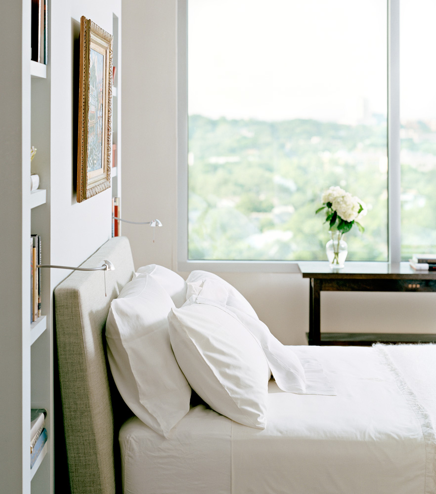 A white bedroom with large windows.
