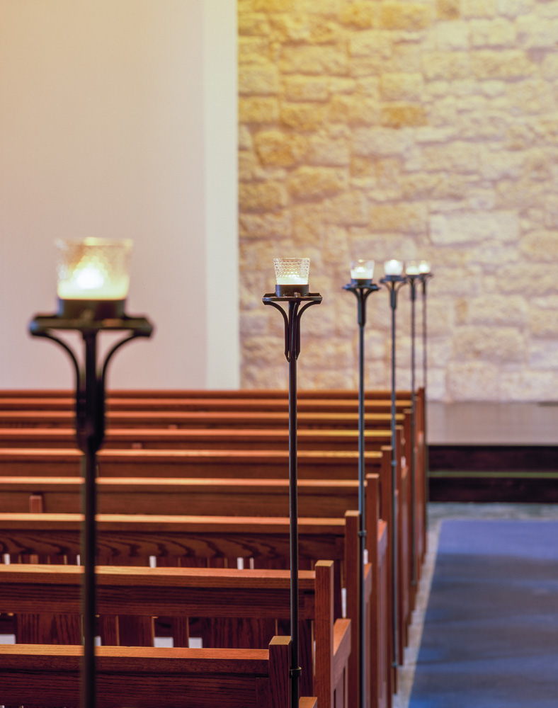 Candles along the pews in a chapel.