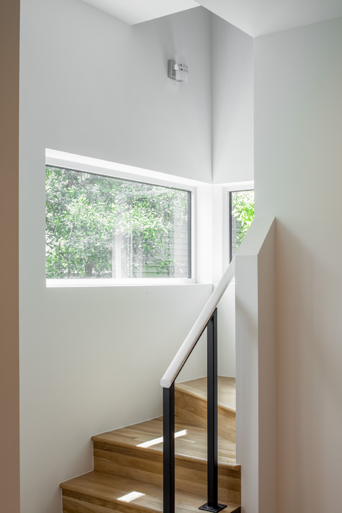 The details of a stair well bending at the corner of a house.