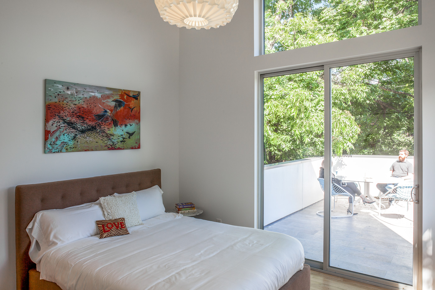 Bedroom connected to a large porch through sliding glass doors.