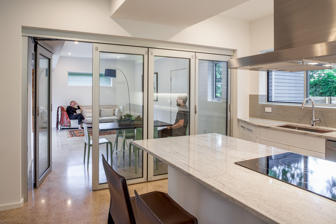 A minimal white kitchen with glass doors that led to a dining and living room.