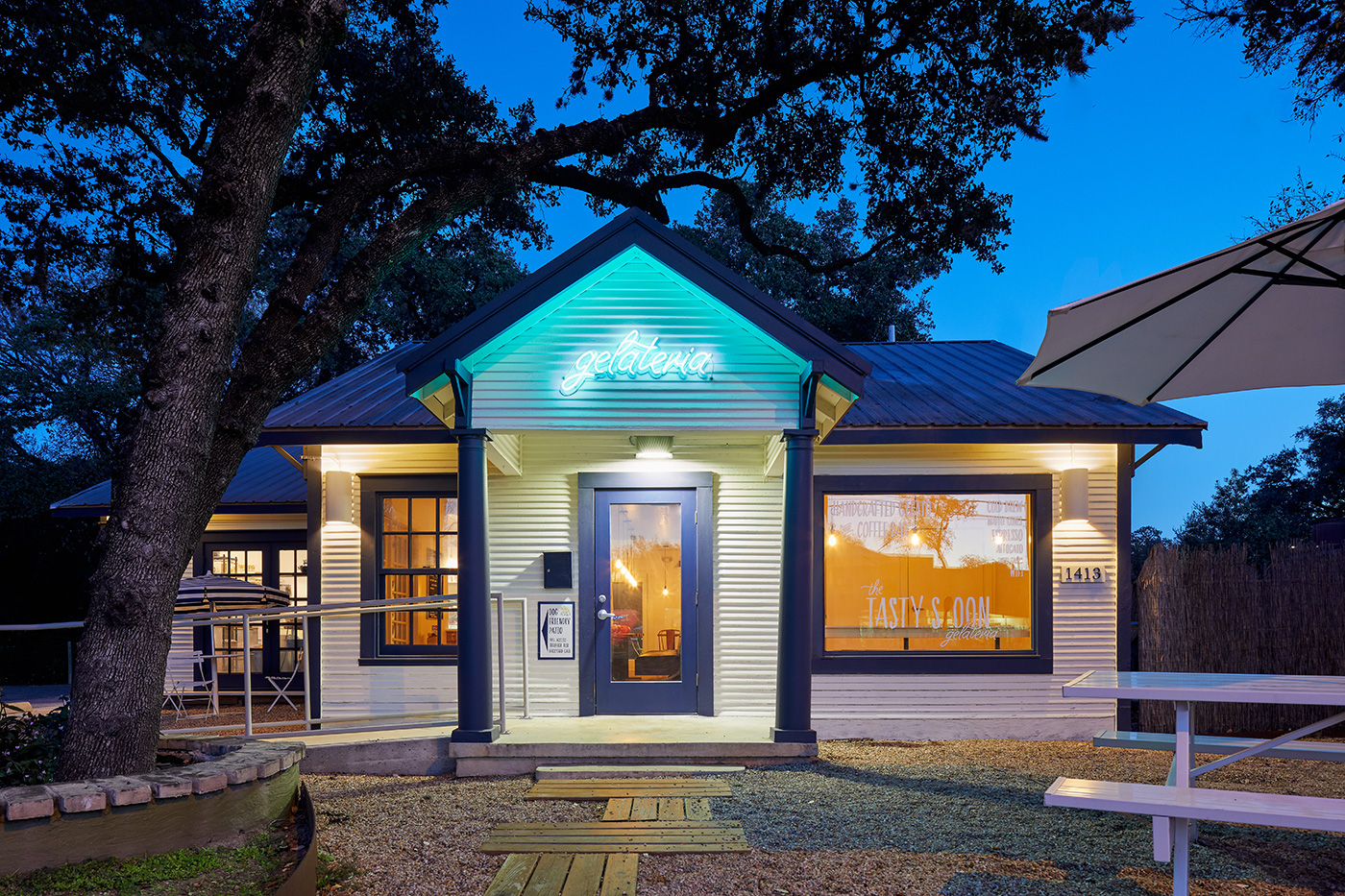 Home like storefront with neone sign above door that reads 