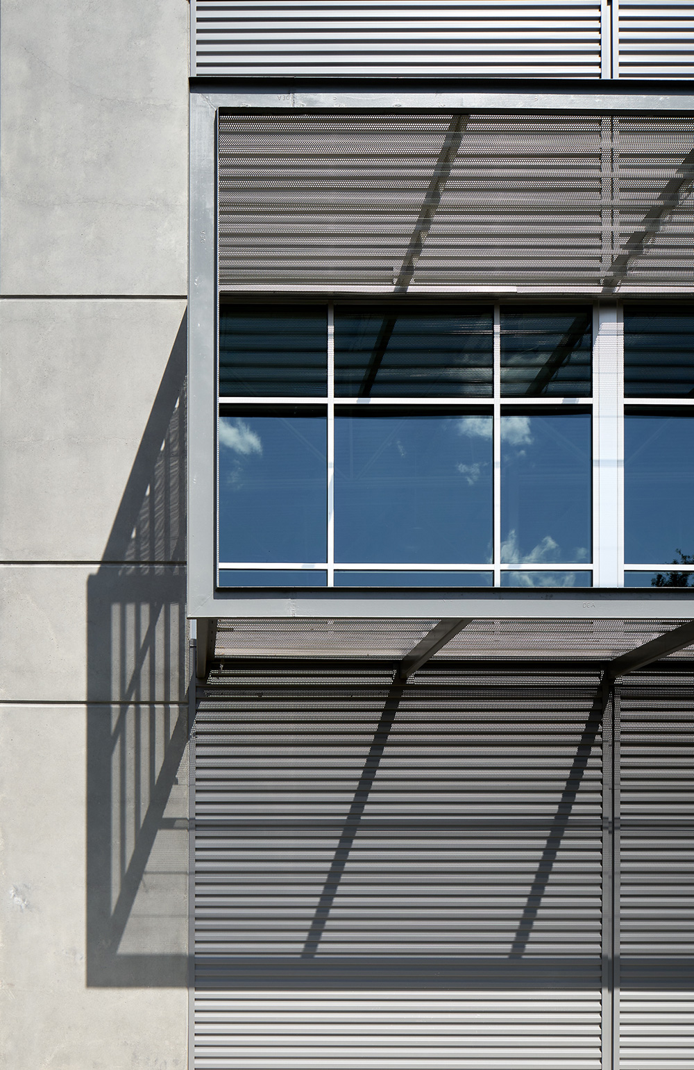 Concrete wall with metal paneling shading window.