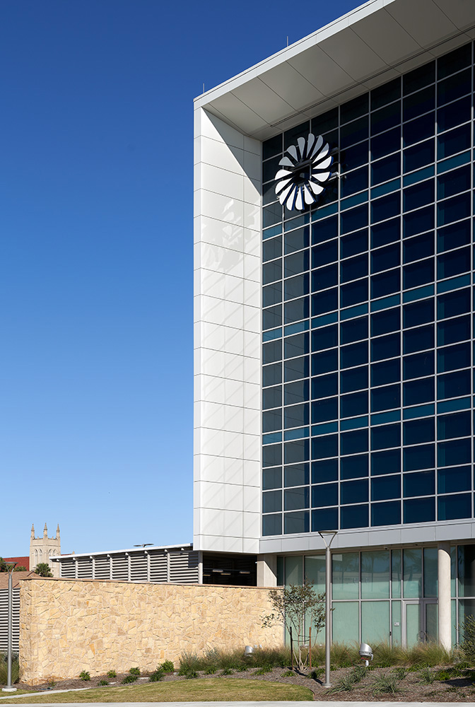 Side view of a glass wall with the Frost bank logo in the corner of the wall.