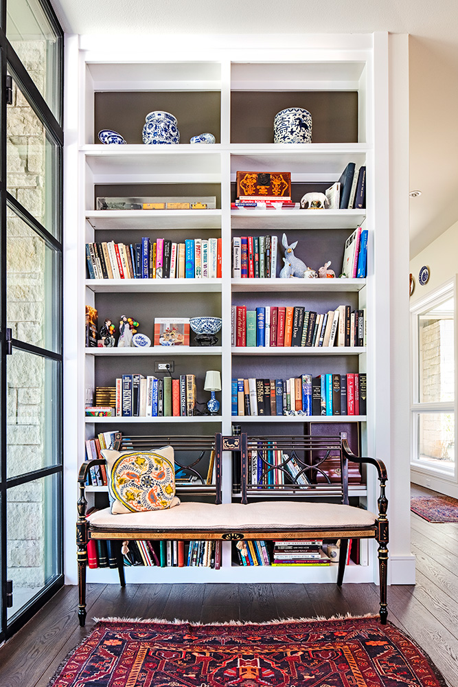 Colorful Bookshelf and rug in white home.