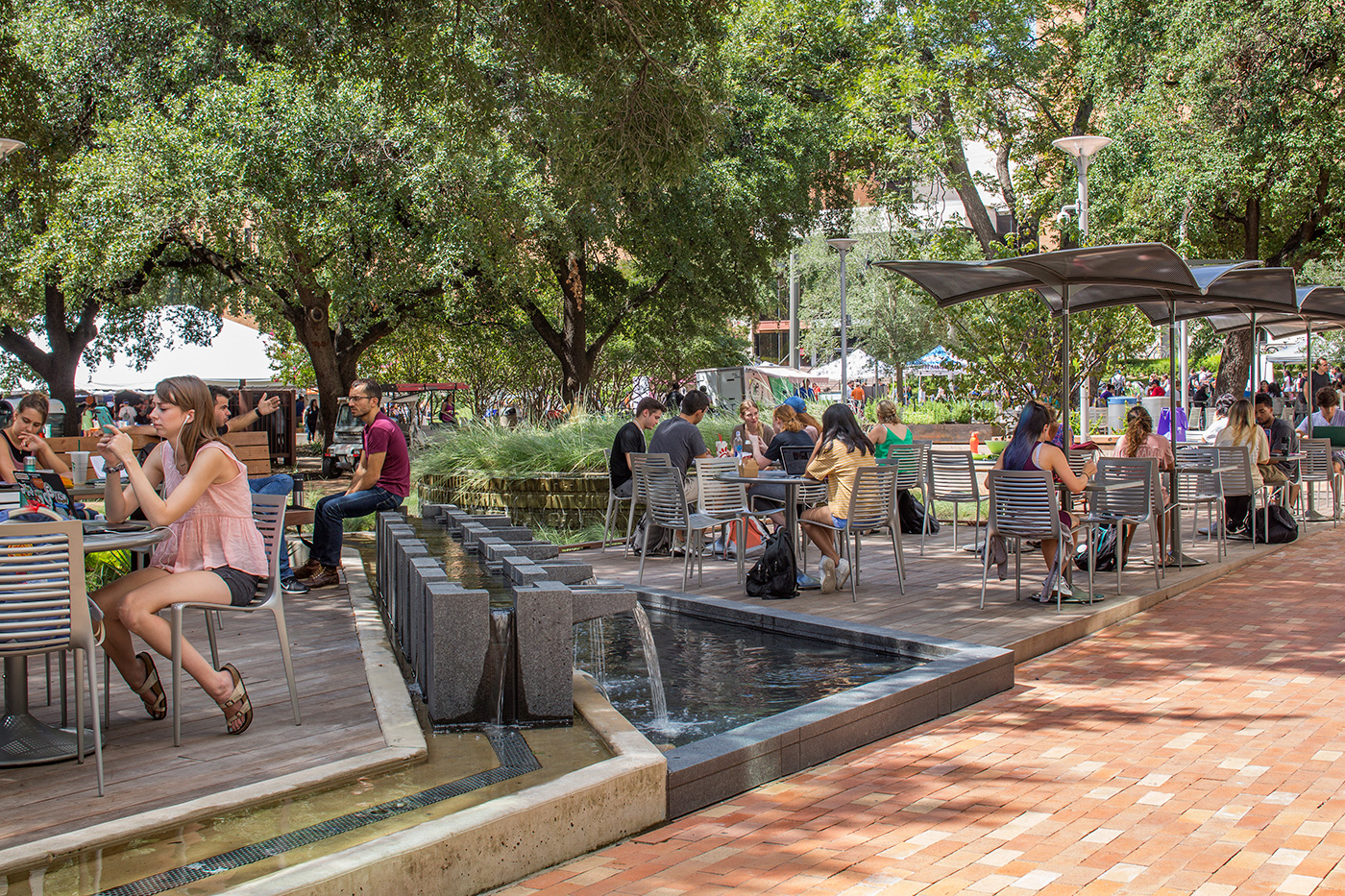 students working and talking with one another at an outdoor seating area.