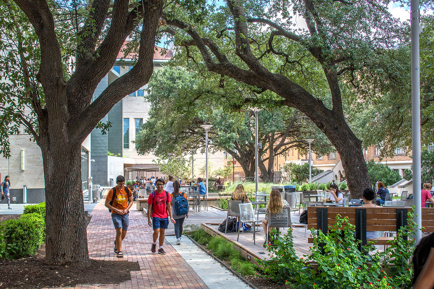 A large outdoor seating area and brick path filled with students.