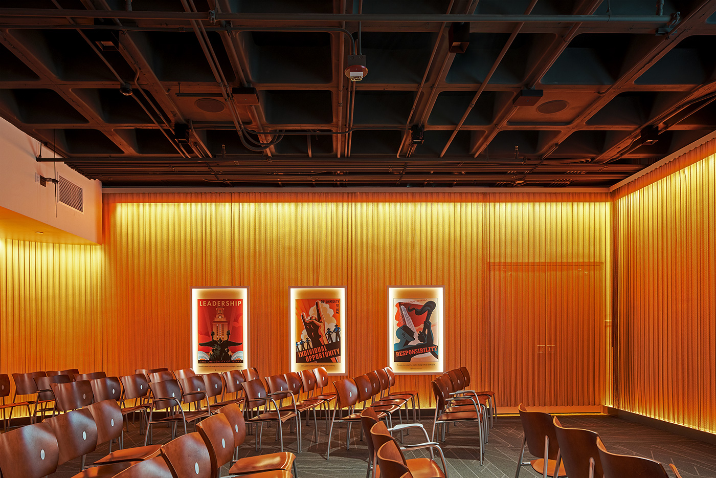 An auditorium room with orange lights coming down on walls.