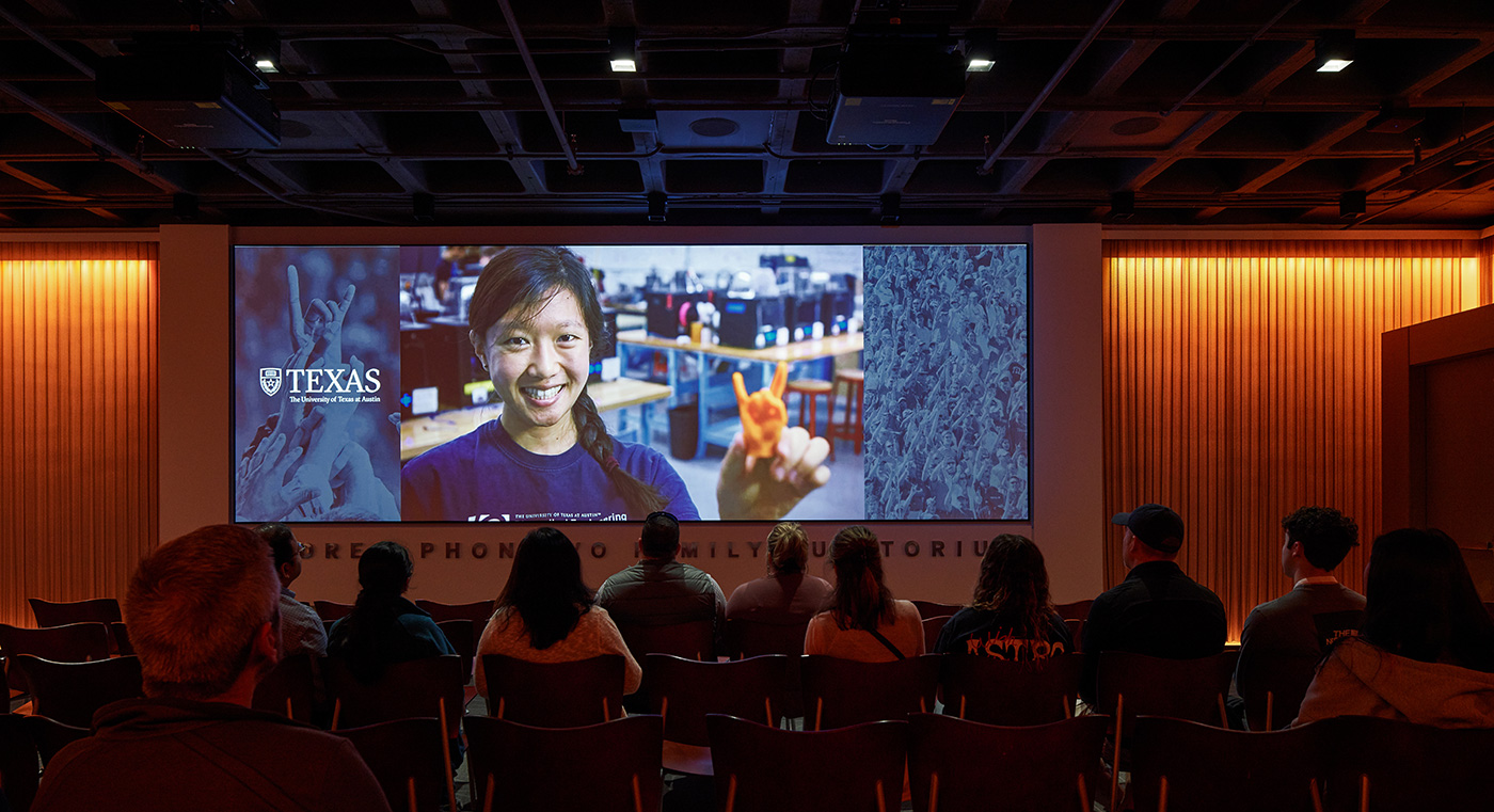 People watching a video in an auditorium.