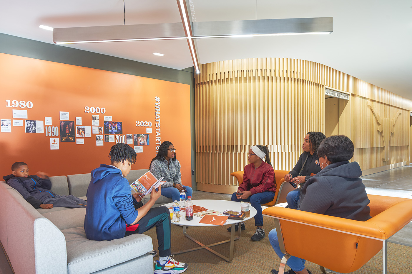 A family sitting around a circular coffee table in a lobby.