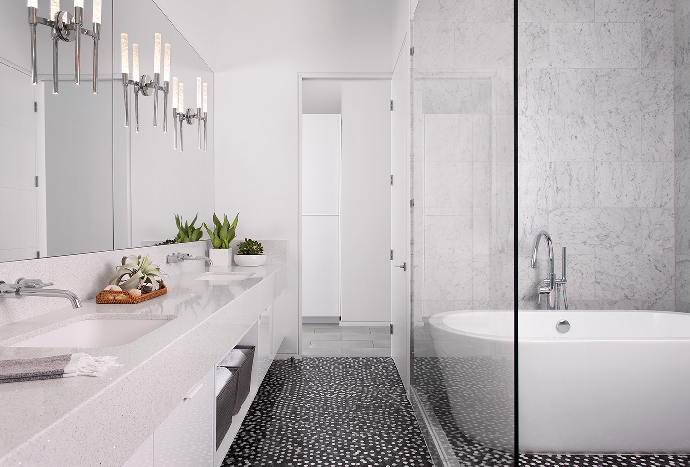 Modern bathroom with dark tile floor and large mirror.