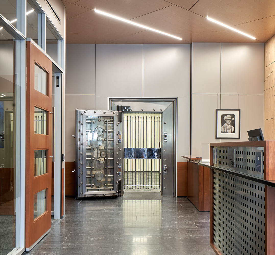 An open vault door Infront of desks.