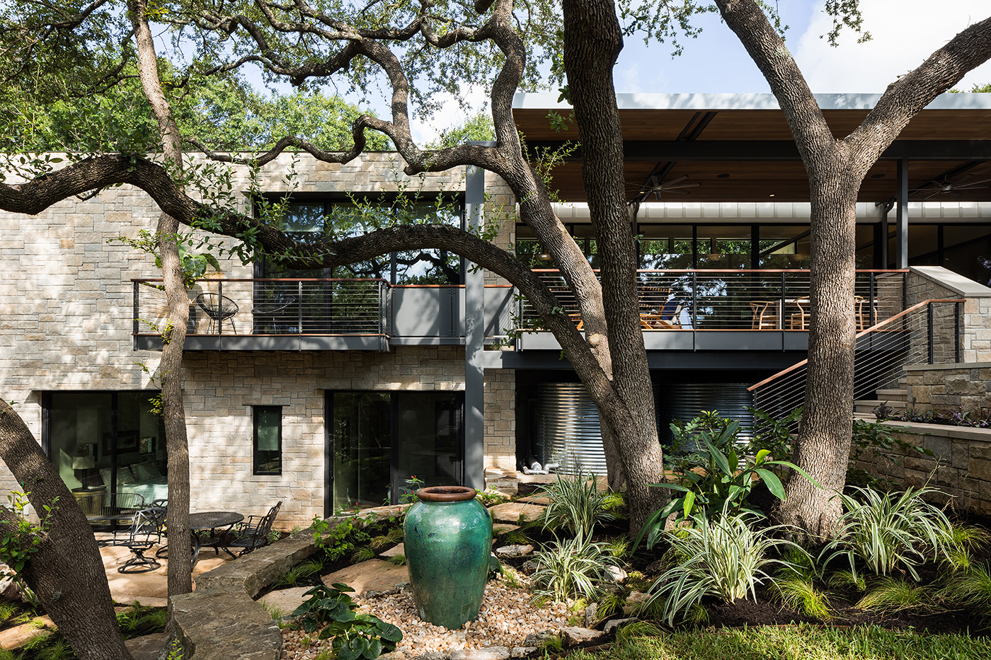 Back yard of a stone and metal house.