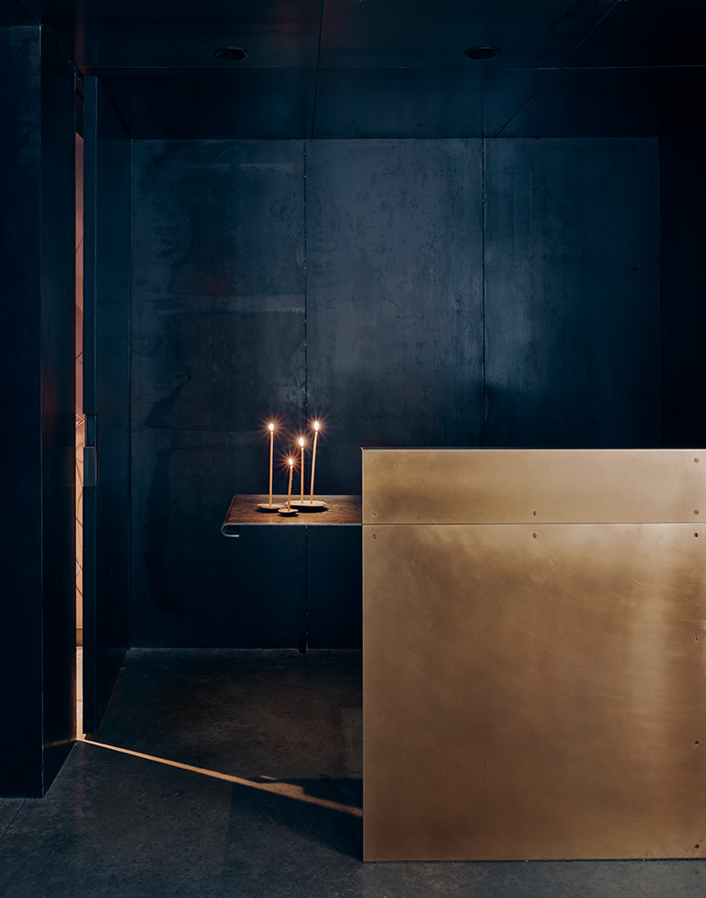 lit candles in a dark metal room.