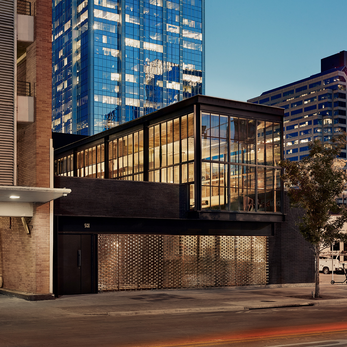 Side view of a black restaurant front a city street.