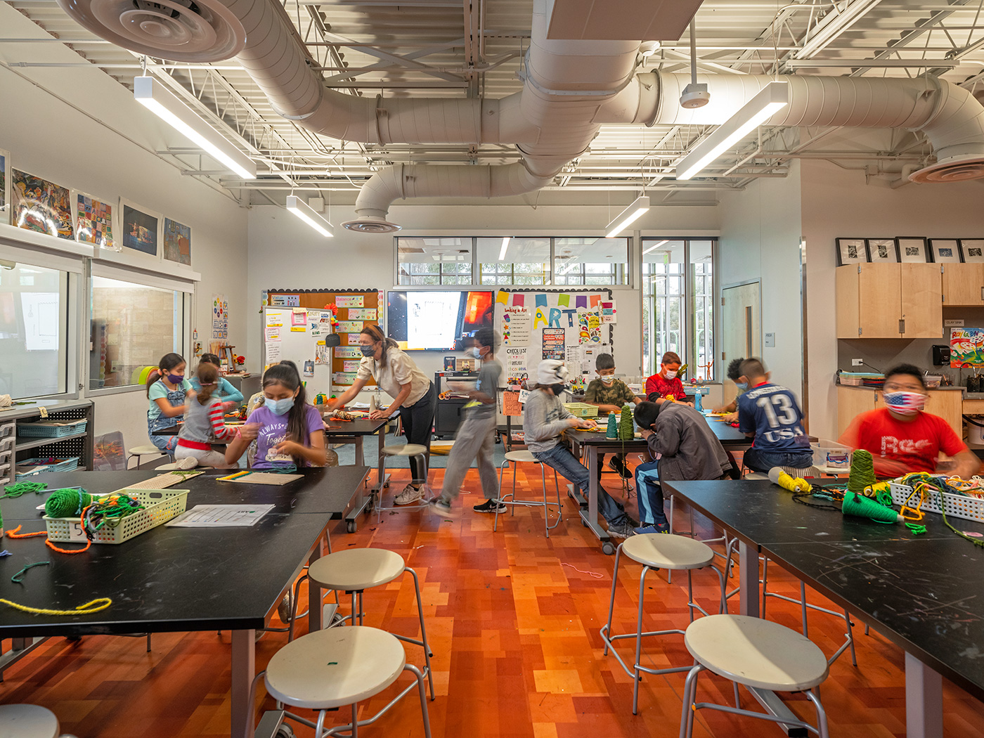 Children working at desks in an art room.